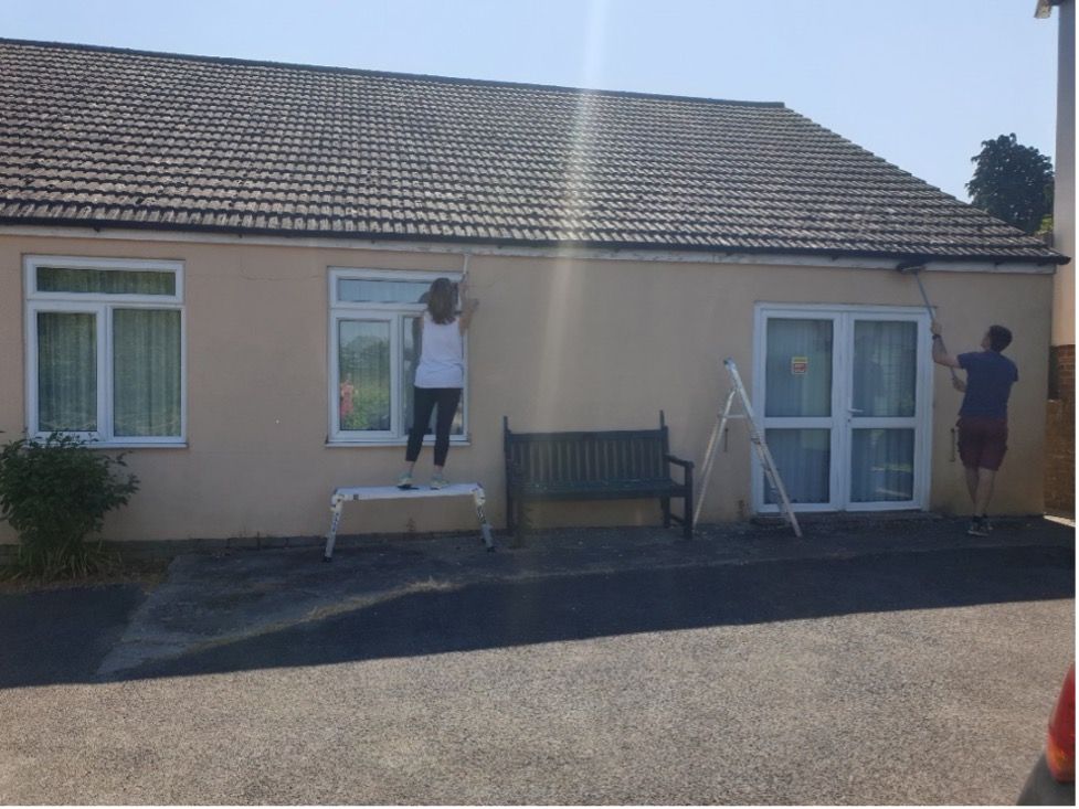 Photo shows the Domainex volunteers painting CraftAbility Centre building